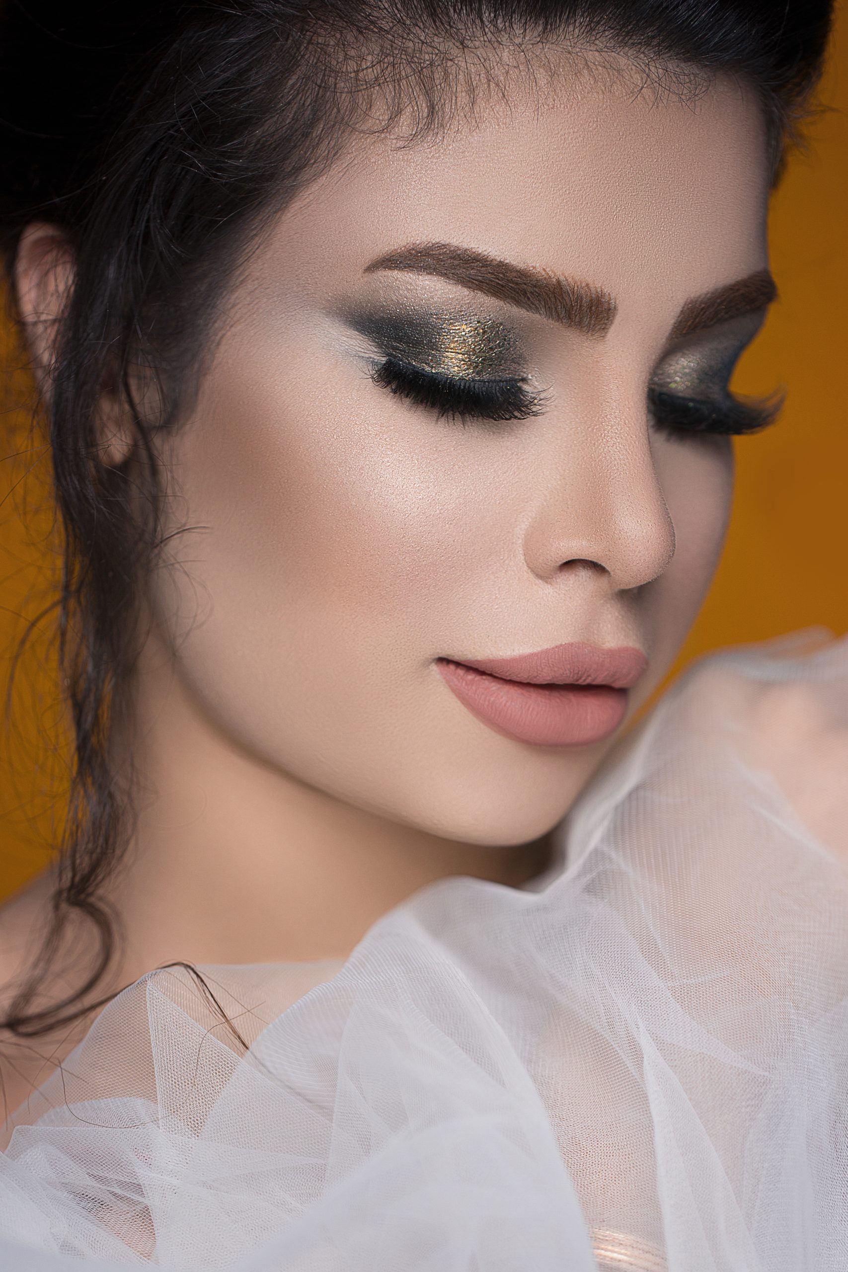 Female model in smokey eyes makeup and wearing pink lipstick